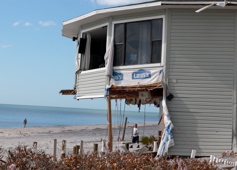 Man walks past home with part of bottom floor missing