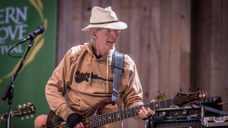 A man plays bass guitar on stage.