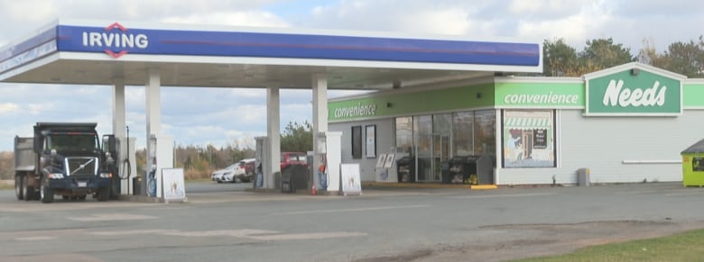 A gas station with a truck parked at one of the pumps. 