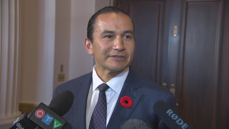 A man in a dark blue suit and a white shirt.