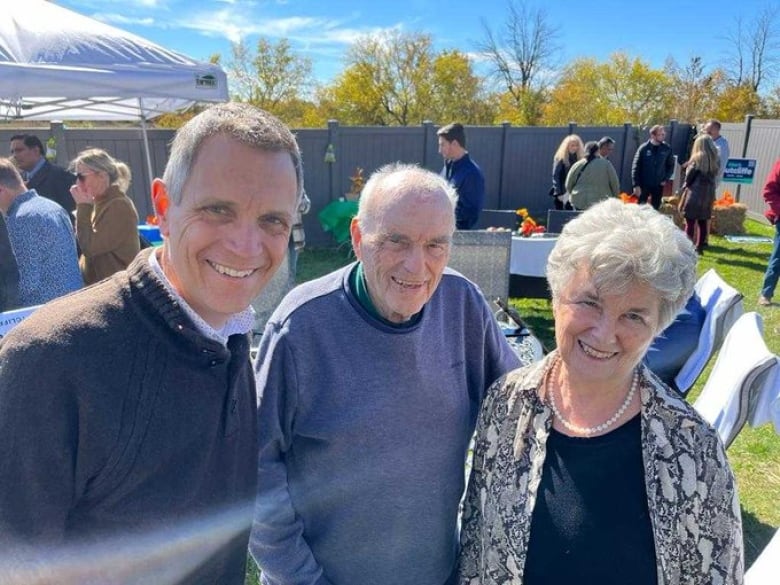 Three people smile at the camera.