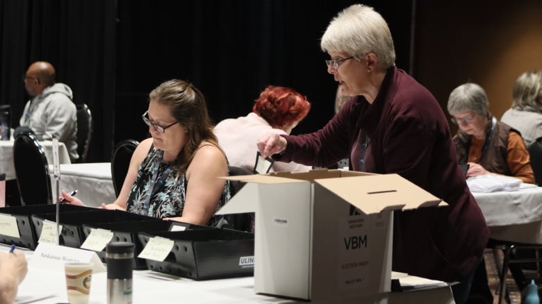 An election worker shows a mail-in vote in the constituency of Saskatoon Westview. The first round mail-in votes are being counted in Regina. 