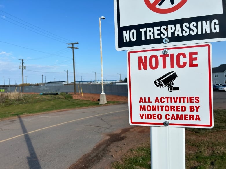 A no trespassing sign and a sign reading 'all activities monitored by video camera.'