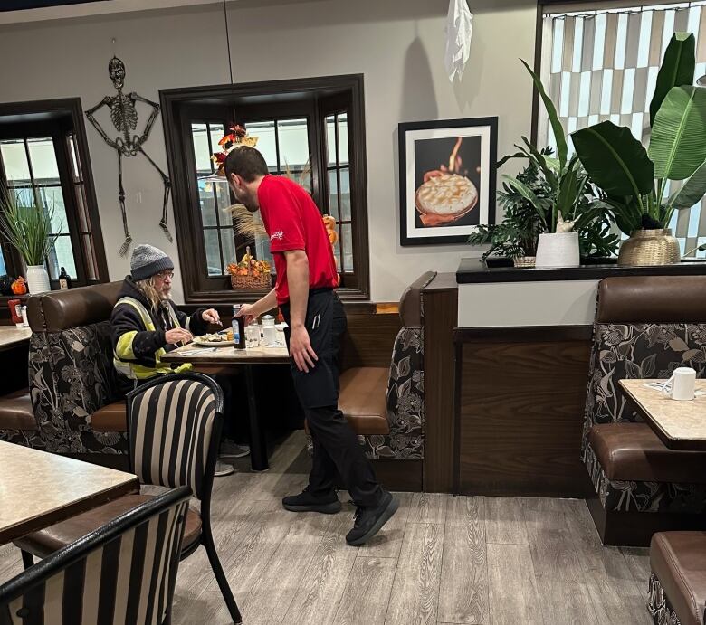 A waiter fills up a customer's coffee cup.