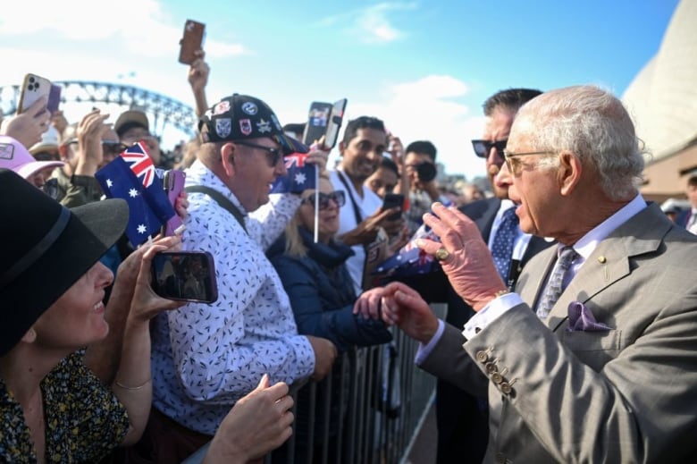 A person shakes hands with people lined up to meet them.