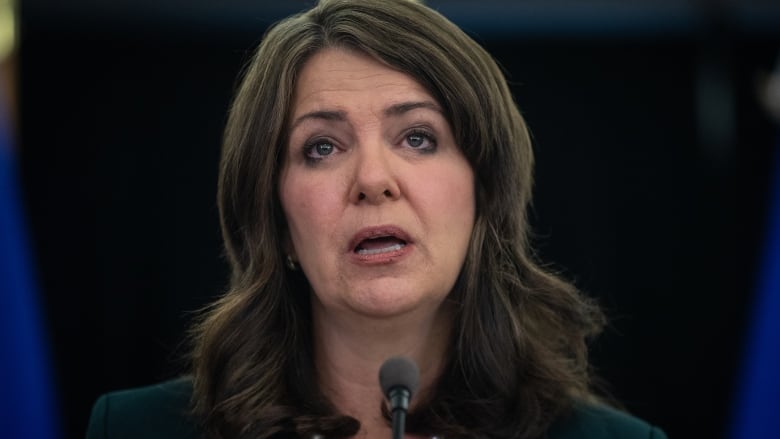 Close up of a woman speaking into a microphone.