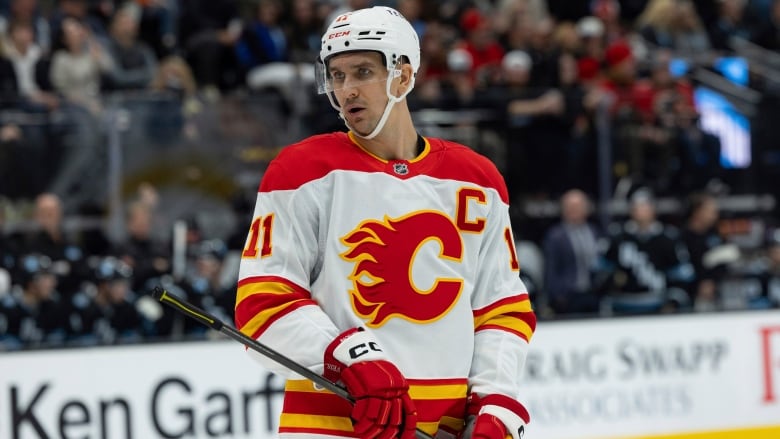 A man wearing hockey equipment and the white and red Calgary Flames team kit.