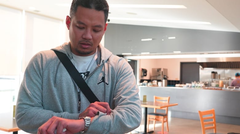 A man checks his watch in an airport.