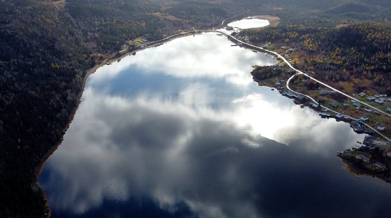 Clouds are reflected in a body of water