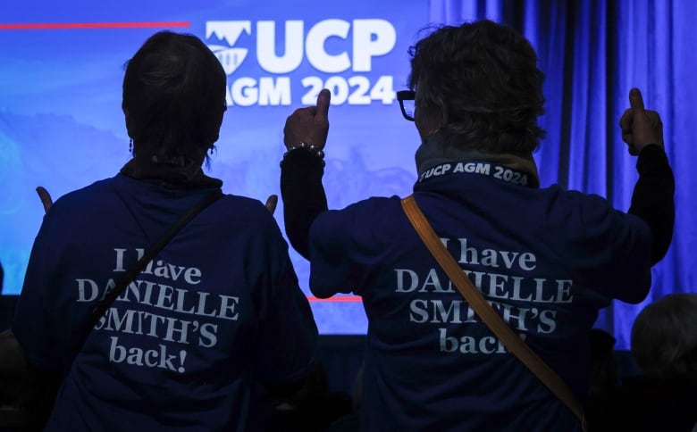 the backs of two women at a political gathering