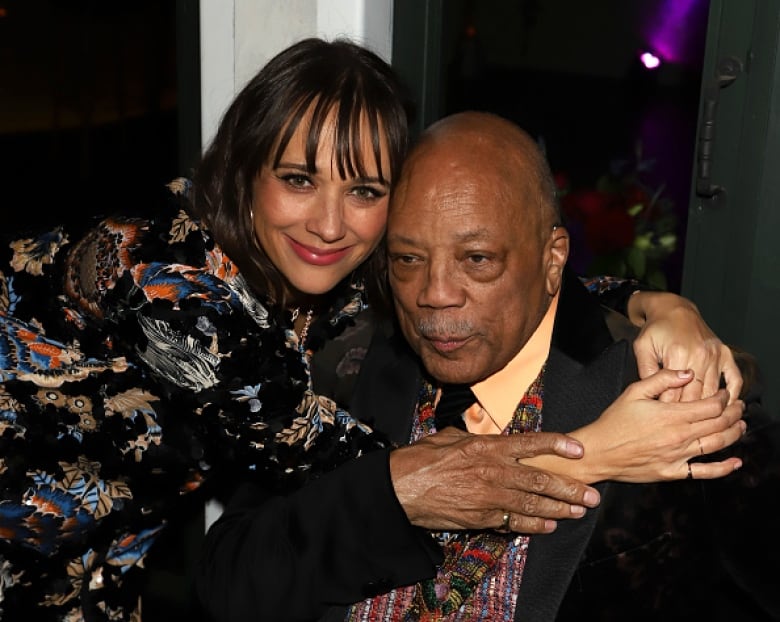 A woman hugs an elderly man.