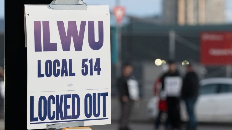 A sign reads 'ILWU Local 514 Locked Out' on a traffic post.