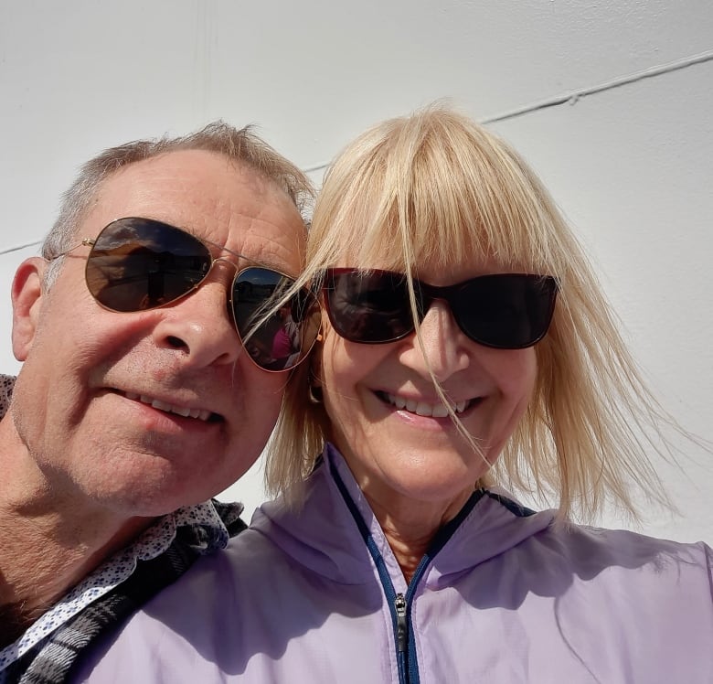 An older man and woman smile for a selfie.