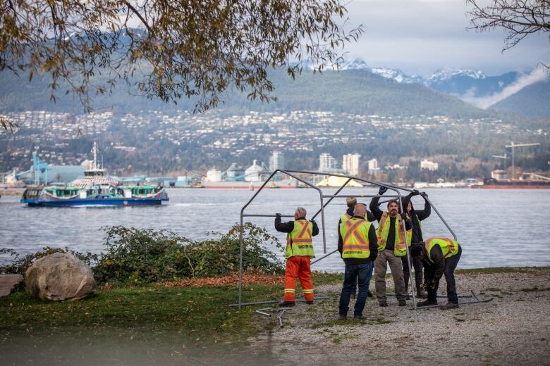 Vancouver Park Board workers wearing high visibility vests take down a structure in a waterfront park