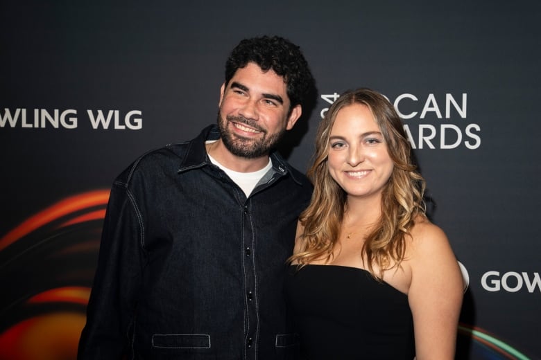 A man and a woman smile for a photo.