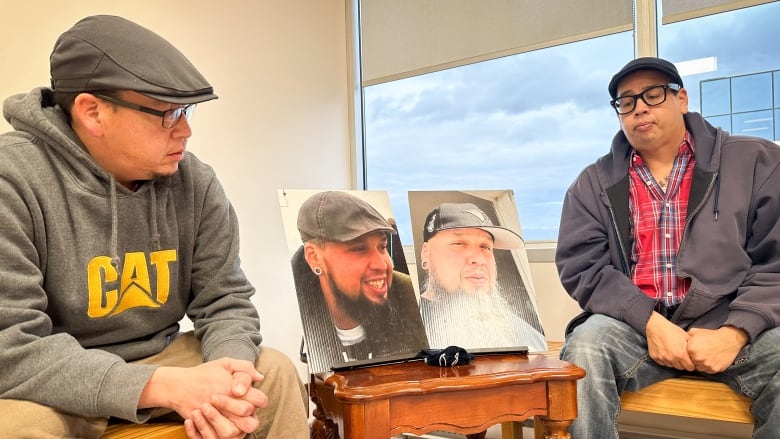 two men, both wearing newsboy caps and glasses, sit on either side of two images depicted a man wearing a hat.