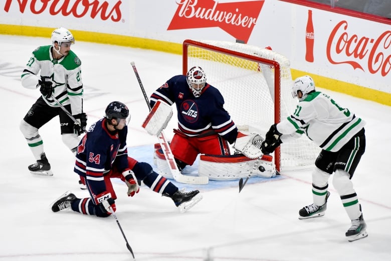 Hockey players around a goalie