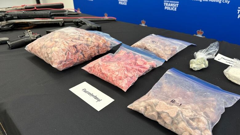 a table with bags of pink dog bone treats and firearms