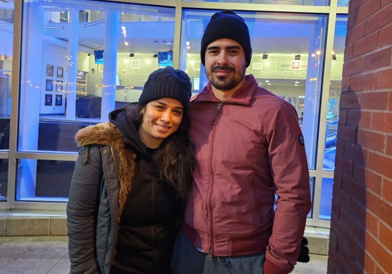 A man and woman stand side by side outside of a building