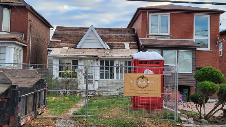 Bungalow with fencing and a sign that says 'Ouroboros Deconstruction'