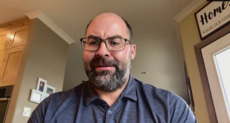 A man is pictured in a home in a screenshot of a Zoom interview.