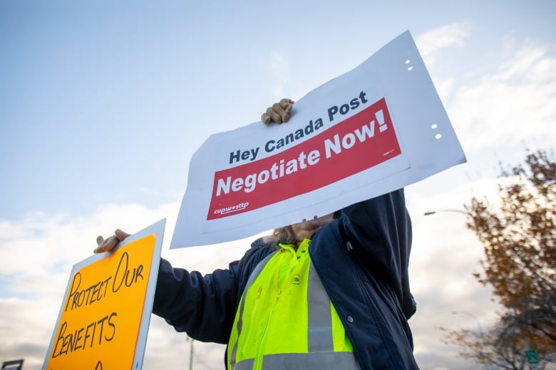 A person holds up a sign that says 