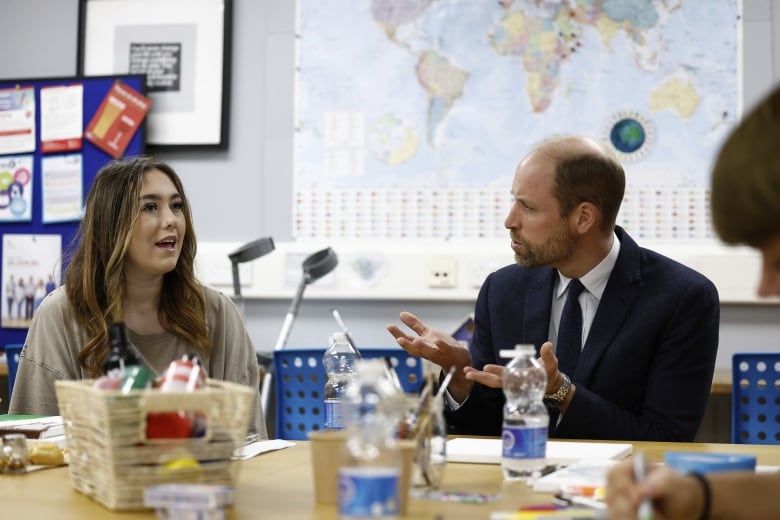 Two people sit at a table.