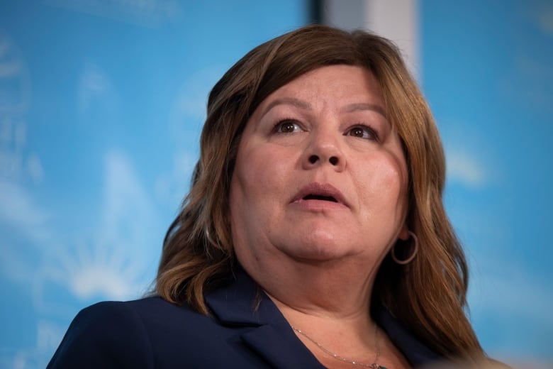 A woman with brown hair looks up.