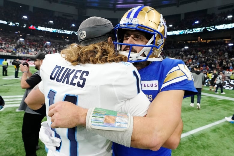 Two football players hug. 