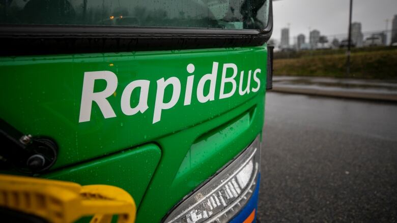 A closeup shot of a green bus front, with the words 'RapidBus' visible.