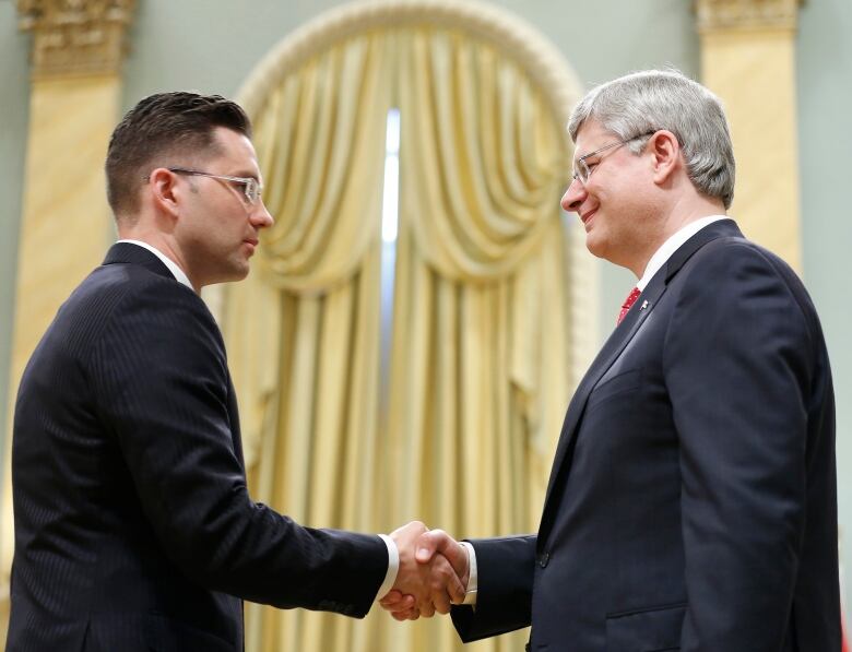 Canadian Prime Minister Stephen Harper (R) shakes hands with Minister of State for Democratic Reform Pierre Poilievre after he was sworn in during a ceremony at Rideau Hall in Ottawa July 15, 2013.