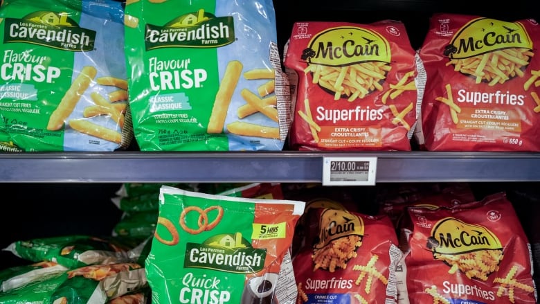 Cavendish and McCain branded potato products are pictured in green and red bags on the shelf at a grocery store.