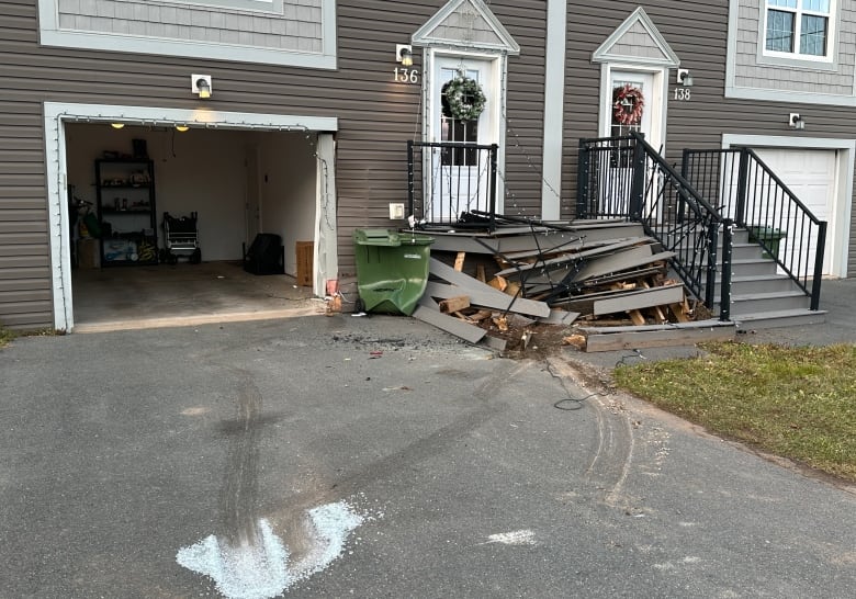 the outside of a damaged house. The porch and outdoor stairs are destroyed. 