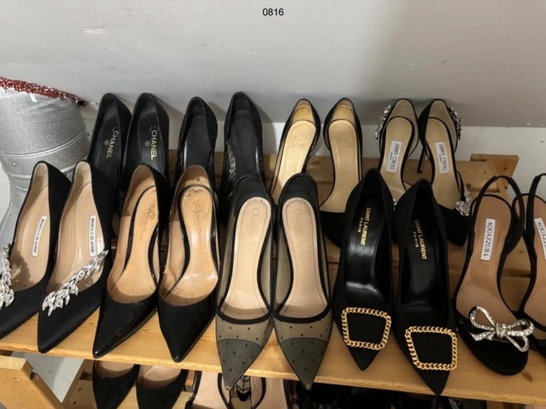 Two rows of shoes on a wooden rack.