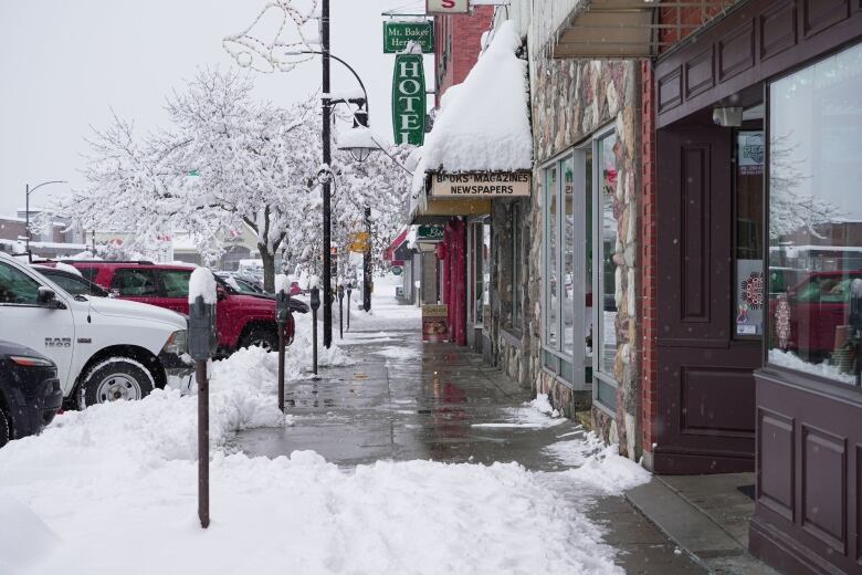 A main street with shops and a hotel is pictured with significant snow accumulations.