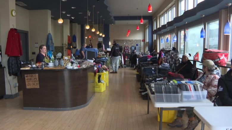 Rows of vendors are seen at an indoor market.