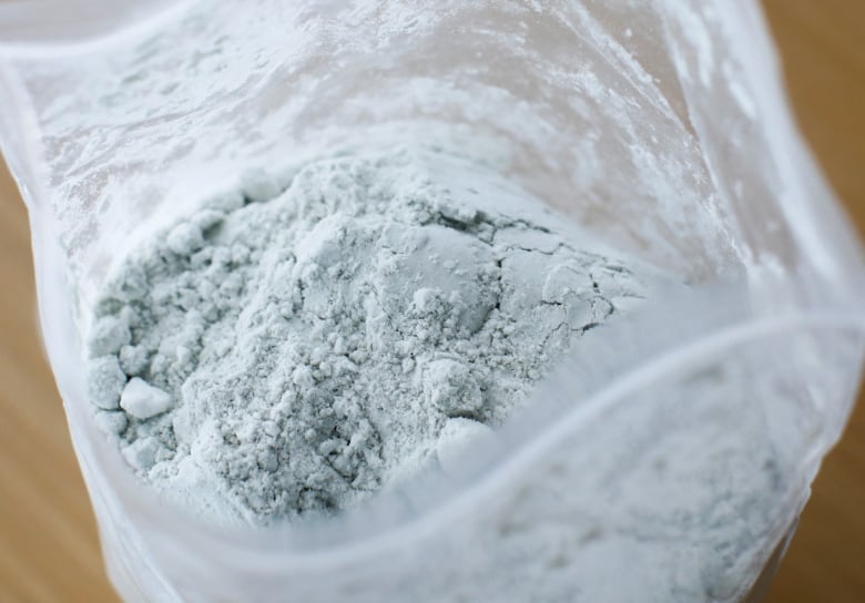 A bag of white-greyish powder is shown.