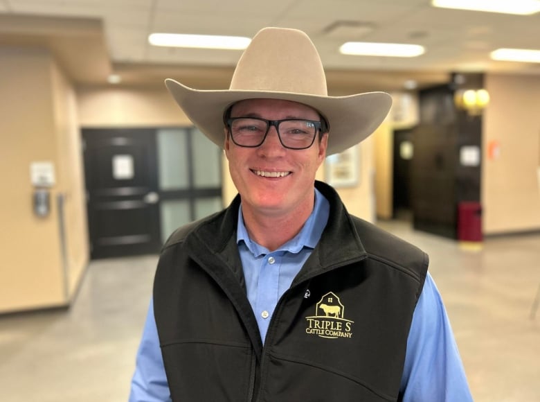 A man in a cowboy hat poses for the camera.